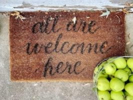 door mat reads all are welcome here