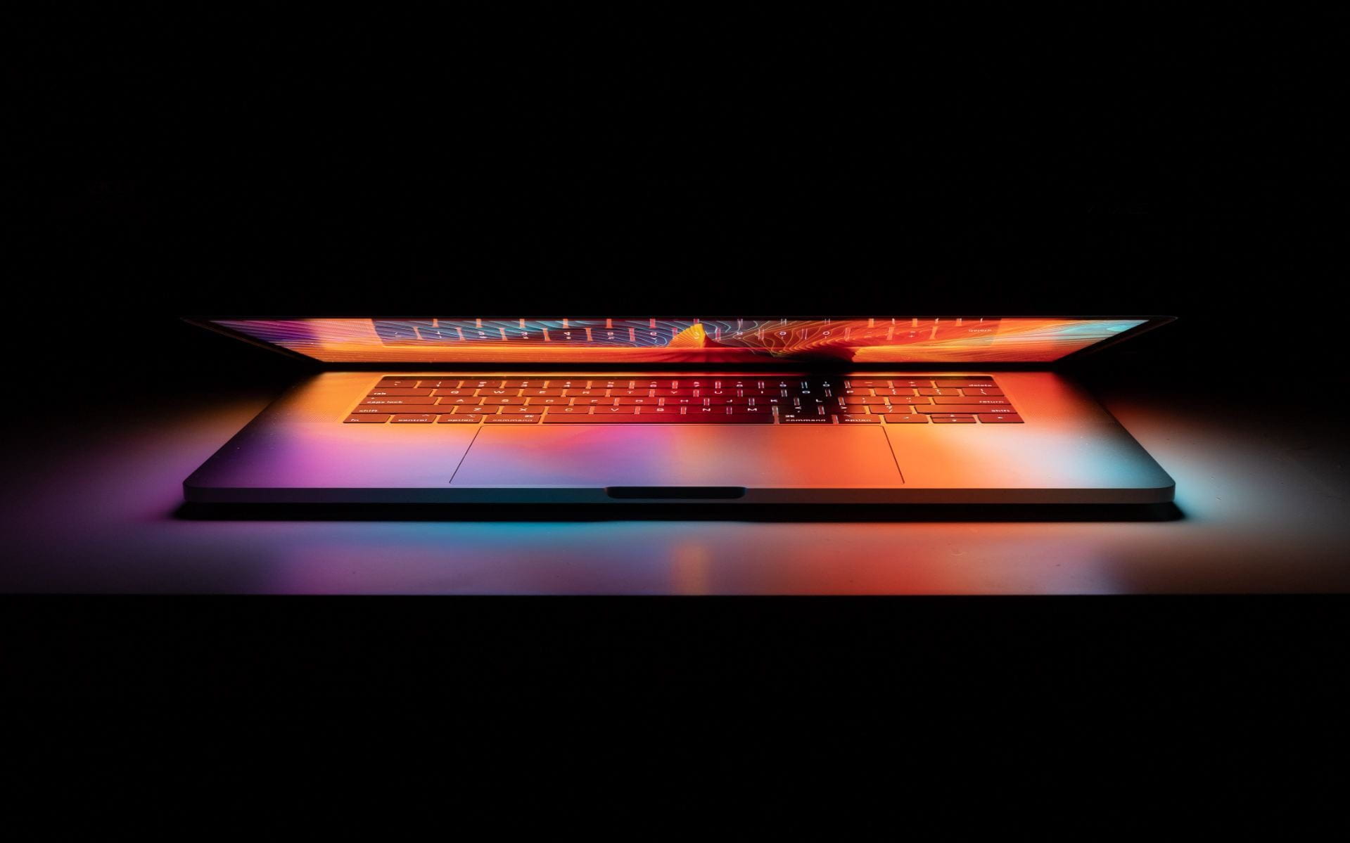 slightly open laptop emitting colorful light